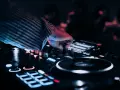 DJ przy konsoli, tworzy muzykę na weselu. Zastanawiasz się, ile zarabia dj na weselu?