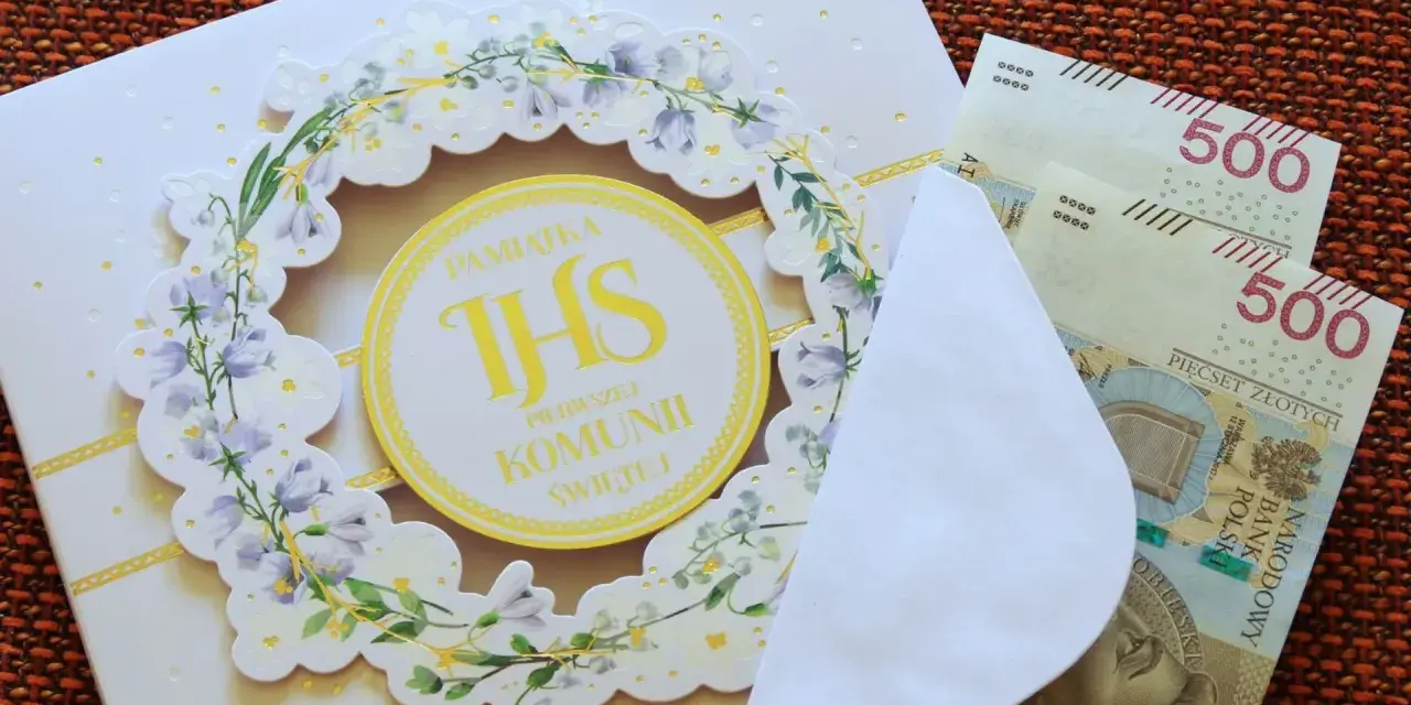 Biała kartka z motywem kwiatowym i napisem "Pamiątka Pierwszej Komunii Świętej", obok koperta z banknotami 500 zł.