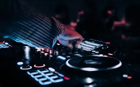 DJ przy konsoli, tworzy muzykę na weselu. Zastanawiasz się, ile zarabia dj na weselu?