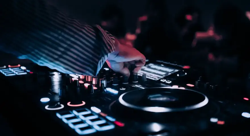 DJ przy konsoli, tworzy muzykę na weselu. Zastanawiasz się, ile zarabia dj na weselu?