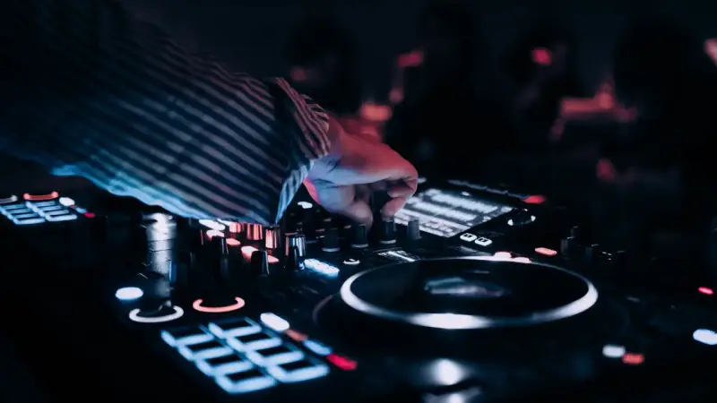 DJ przy konsoli, tworzy muzykę na weselu. Zastanawiasz się, ile zarabia dj na weselu?